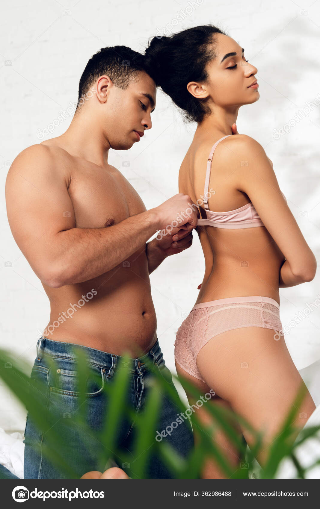 Man unfastening woman's bra Stock Photo