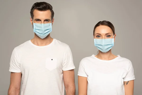 Jong Paar Medische Maskers Kijken Naar Camera Geïsoleerd Grijs — Stockfoto