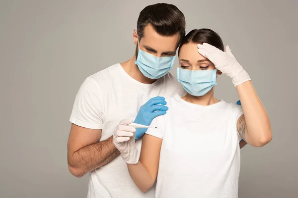 Hombre Guantes Látex Abrazando Novia Con Termómetro Mano Cerca Frente — Foto de Stock