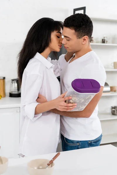 African American Woman Holding Container Breakfast Cereal Hugging Kissing Man — Stock Photo, Image