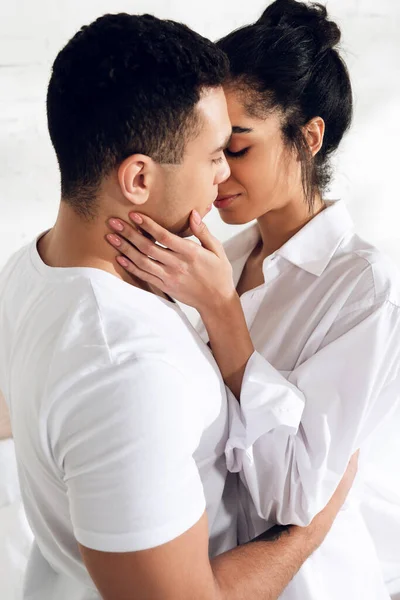 Międzyrasowy Para Przytulanie Całowanie Zamkniętymi Oczami Sypialni — Zdjęcie stockowe