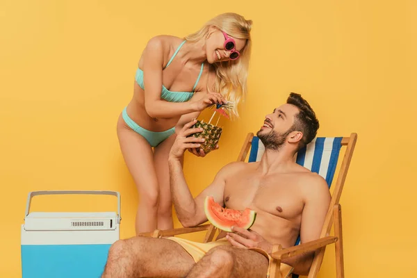 Cheerful Blonde Girl Giving Pineapple Cocktail Handsome Man Sitting Deck — Stock Photo, Image