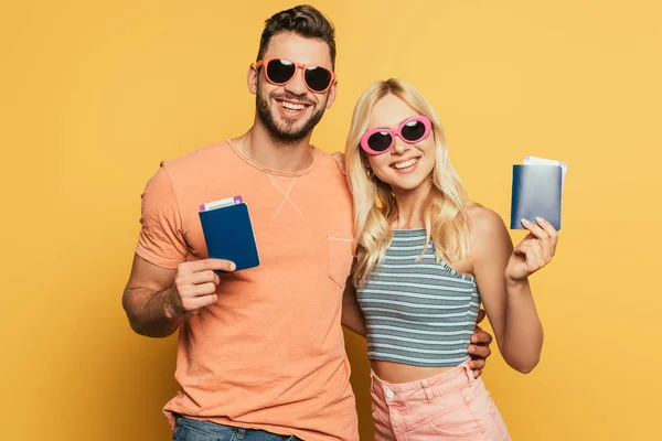 Happy Young Couple Sunglasses Showing Passports Air Tickets Yellow Background — Stock Photo, Image