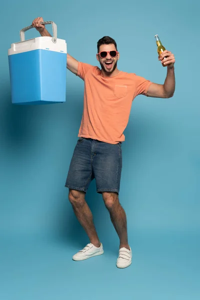 Cheerful Man Sunglasses Holding Bottle Beer Portable Fridge Blue Background — Stock Photo, Image