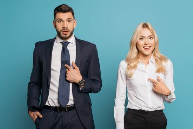 Şaşırtıcı iş adamı ve iş kadını mavi arka planda kendilerini gösteriyorlar.