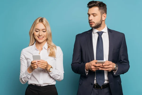 Glimlachende Zakenvrouw Nieuwsgierige Zakenman Met Behulp Van Smartphones Blauwe Achtergrond — Stockfoto