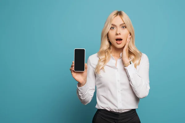 Shocked Businesswoman Touching Face While Holding Smartphone Blank Screen Blue — Stock Photo, Image