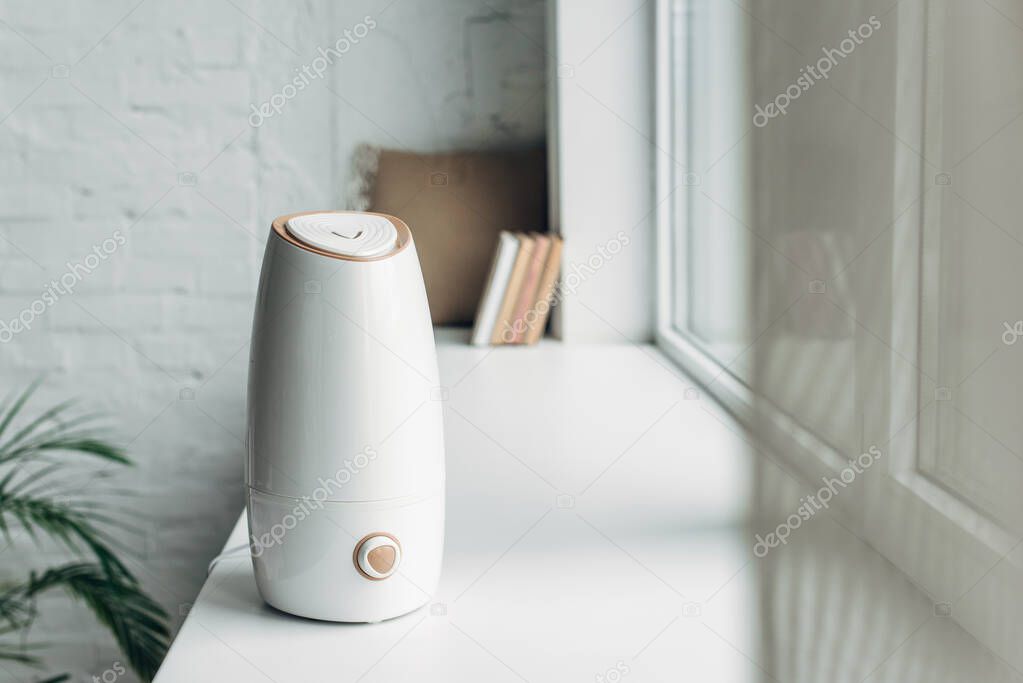 white ultrasonic purifier standing on windowsill at home