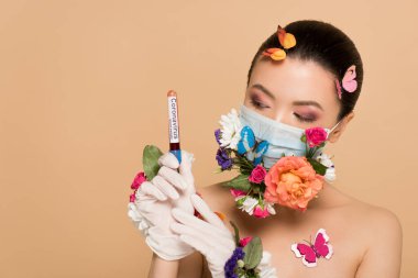Lateks eldivenli, çiçekli maskeli, kelebekli, koronavirüs kan testi yapan seksi, çıplak Asyalı bir kız.