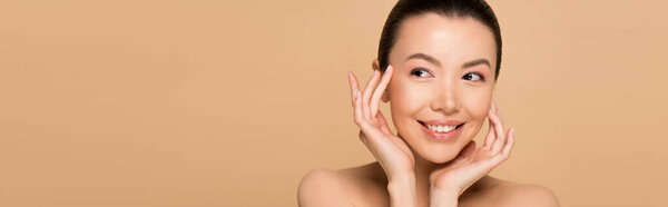 panoramic shot of attractive cheerful asian girl with nude makeup isolated on beige