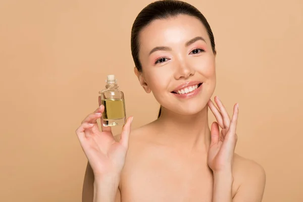 Atraktivní Veselý Akt Asijské Dívka Použití Olej Tvář Izolované Béžové — Stock fotografie