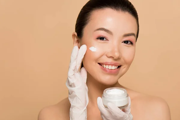 Attractive Cheerful Nude Asian Girl Latex Gloves Applying Face Cream — Stock Photo, Image