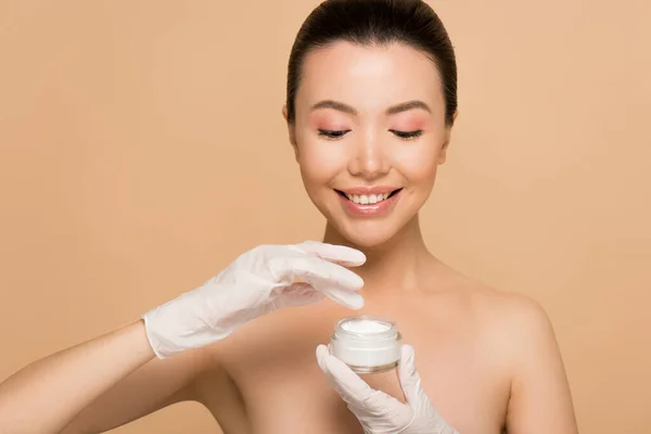 Attractive Happy Nude Asian Girl Latex Gloves Applying Face Cream — Stock Photo, Image