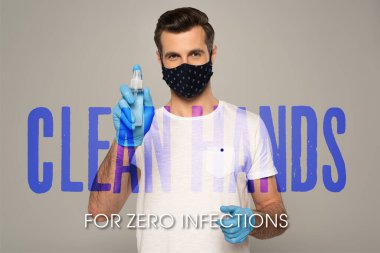 Lastik eldivenli ve güvenlik maskeli bir adam el dezenfektanı tutuyor. Gri, temiz ellerde sıfır enfeksiyon çizimi için izole edilmiş. 