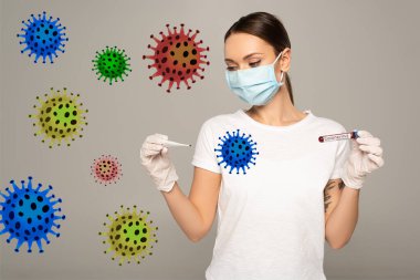 Tıbbi maskeli kadın termometre ve test tüpü tutuyor. Kan örneği ve koronavirüs harfleri gri renkli, bakteri çizimlerinde izole edilmiş. 