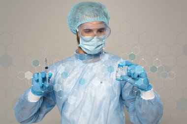 Tıbbi maskeli doktor ve koruyucu Google 'lar aşı kavanozu ve şırıngayı gri hücre örneklerine izole ediyor.