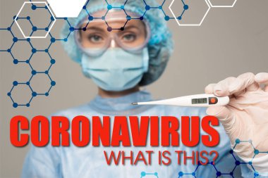 Güvenli Google 'daki doktorun seçici odak noktası termometreyi gri, koronavirüs üzerinde izole ediyor.