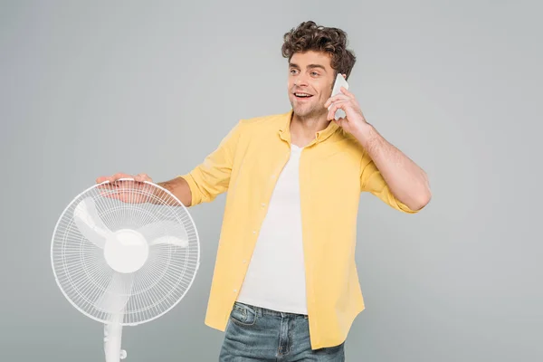 Hombre Sonriendo Hablando Teléfono Inteligente Cerca Ventilador Eléctrico Aislado Gris — Foto de Stock