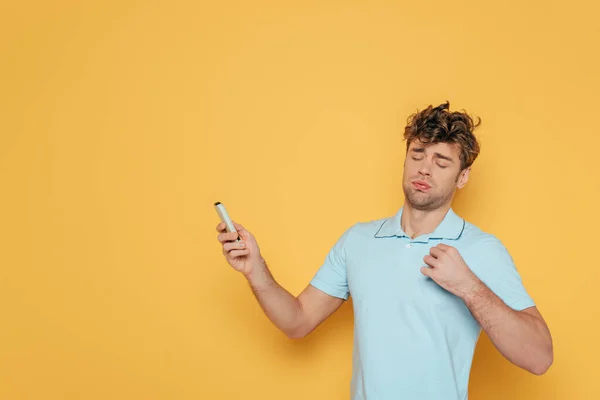 Homem Com Controle Remoto Mão Estendida Sofrendo Calor Amarelo — Fotografia de Stock