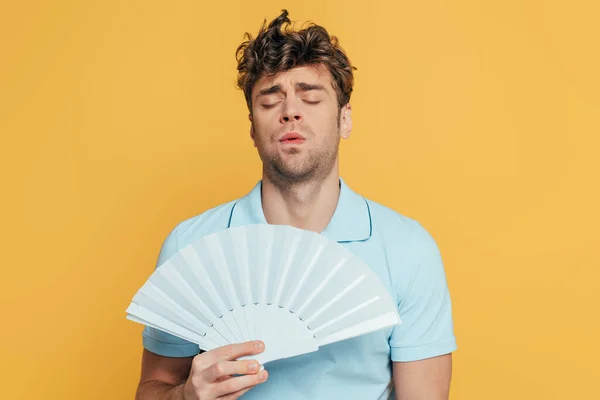 Homem Com Olhos Fechados Ventilador Mão Sofrendo Calor Isolado Amarelo — Fotografia de Stock