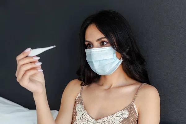 Sıhhiye Maskeli Hasta Kız Kendini Izole Ederken Termometreye Bakıyor — Stok fotoğraf