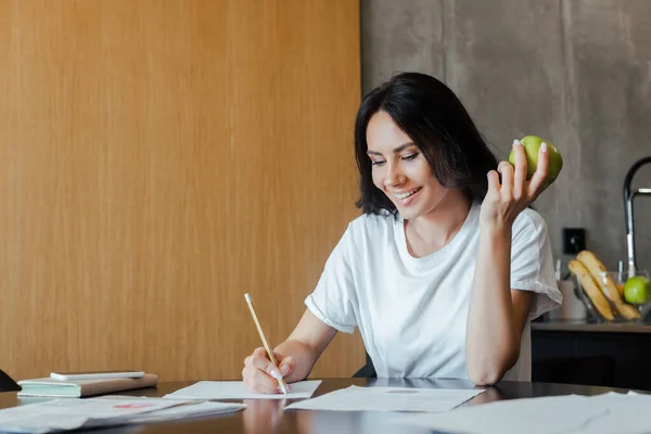 Glad Flicka Som Arbetar Med Affärshandlingar Och Hålla Äpple Hemma — Stockfoto