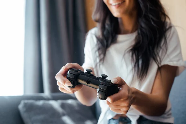 KYIV, UKRAINE - 9 Nisan 2020: kendini izole eden, seçici odaklanma üzerine oyun oynayan mutlu bir kadının görüntüsü