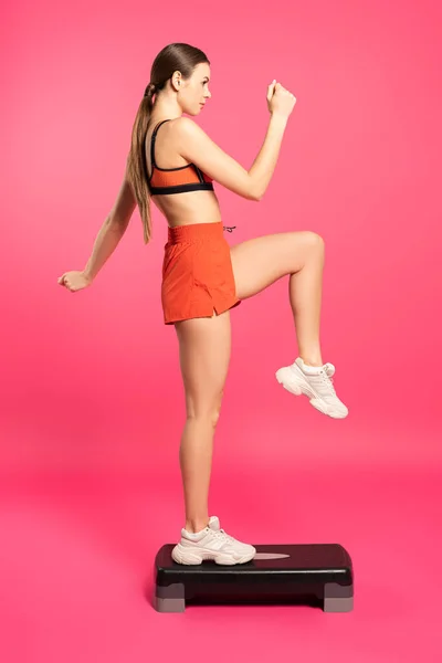 Вид Сбоку Привлекательной Женщины Выполняющей Упражнения Ступеньках Розовой Платформе — стоковое фото