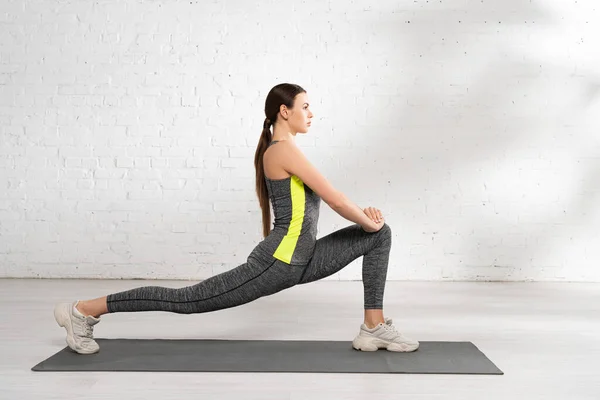 Side View Flexible Sportswoman Exercising Fitness Mat White Brick Wall — Stock Photo, Image