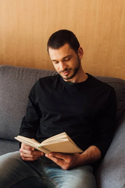 Schöner Und Bärtiger Mann Liest Buch Während Wohnzimmer Sitzt — Stockfoto