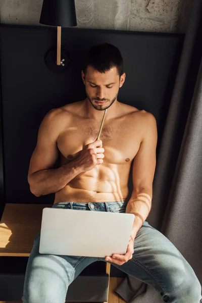 Freelancer Barbudo Sem Camisa Segurando Lápis Olhando Para Laptop — Fotografia de Stock