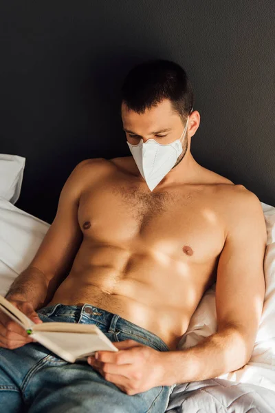 Hombre Musculoso Máscara Médica Libro Lectura Cama —  Fotos de Stock