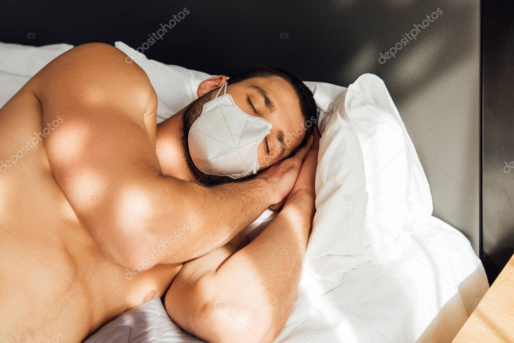 muscular man in medical mask sleeping in bedroom 