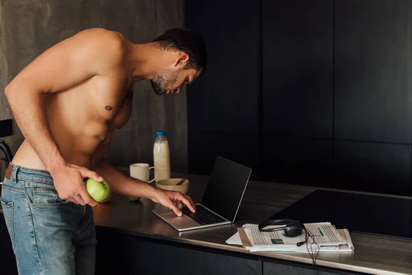 Muskelfrilansare Som Håller Äpple Och Använder Laptop Med Blank Skärm — Stockfoto