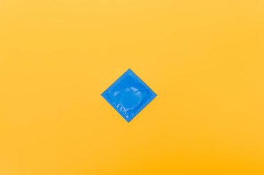 top view of blue pack with condom isolated on orange clipart