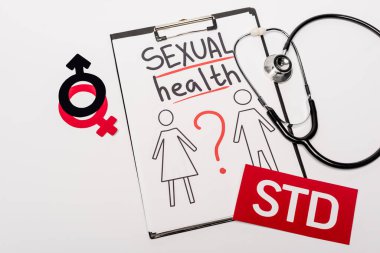 top view of clipboard with sexual health lettering, drawn man and woman near stethoscope, gender signs and std isolated on white  clipart