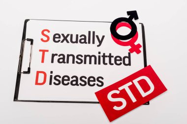 top view of clipboard with sexually transmitted diseases near gender symbols and std lettering isolated on white clipart
