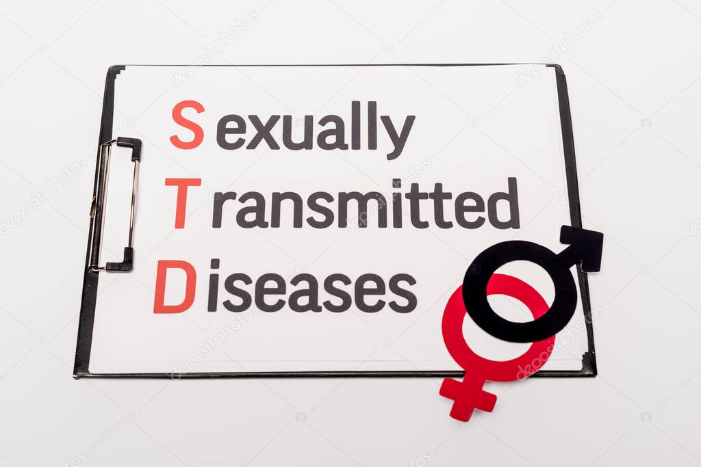 top view of clipboard with sexually transmitted diseases near gender symbols isolated on white