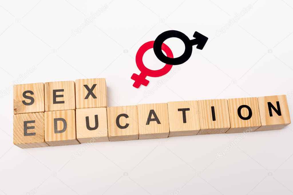 top view of wooden cubes with sex education lettering and gender symbols isolated on white 