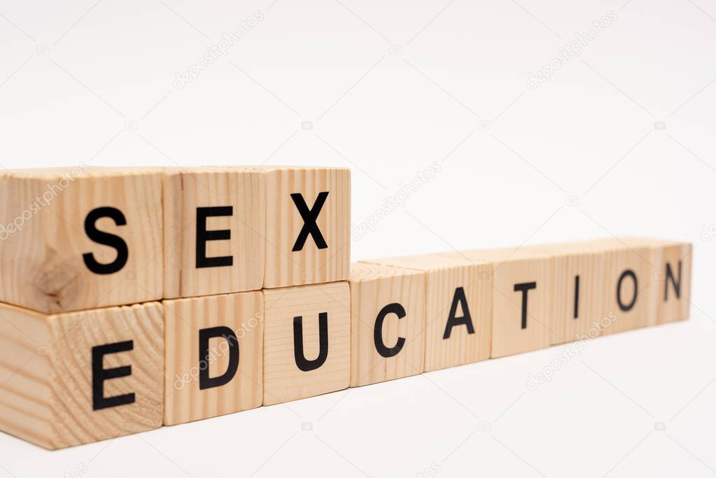 selective focus of wooden cubes with sex education lettering isolated on white 