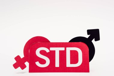 Beyaz üzerine STD harfleri yazılmış kağıdın yanında cinsiyet sembolleri