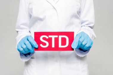 Mavi lateks eldivenli, beyaz ceketli, gri renkli stad harfli doktor manzaralı.