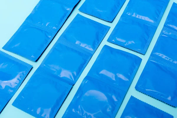 Packungen Mit Verhütungskondomen Isoliert Auf Blauem Grund — Stockfoto