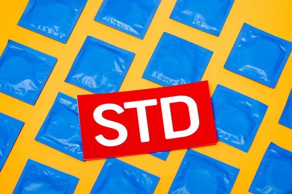 Top View Paper Std Lettering Blue Packs Condoms Isolated Orange — Stock Photo, Image