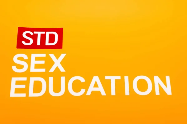 关于性教育和用橙色隔离的粗体字母的顶级视图 — 图库照片