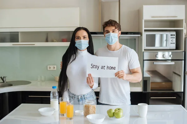 Ill Couple Medical Masks Having Breakfast Holding Stay Home Sign — Stock Photo, Image