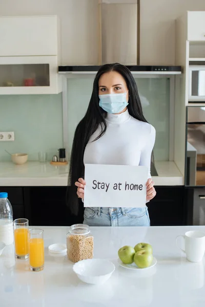 戴着医疗面罩的生病妇女在家里吃早餐时 自理地待在家里 — 图库照片