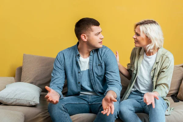 Young Couple Quarreling Sofa Yellow Wall — Stock Photo, Image