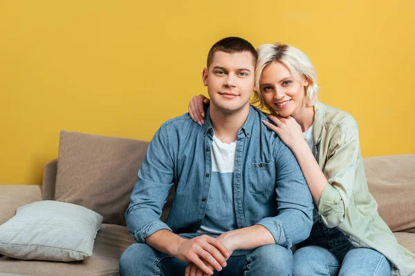 Happy Young Couple Hugging Sofa Yellow Wall — Stock Photo, Image