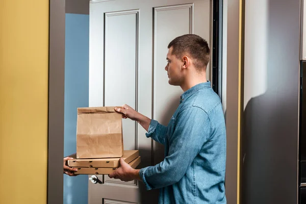 Delivery Man Δίνοντας Πακέτο Νεαρό Άνδρα Κοντά Ανοιχτή Πόρτα Στο — Φωτογραφία Αρχείου